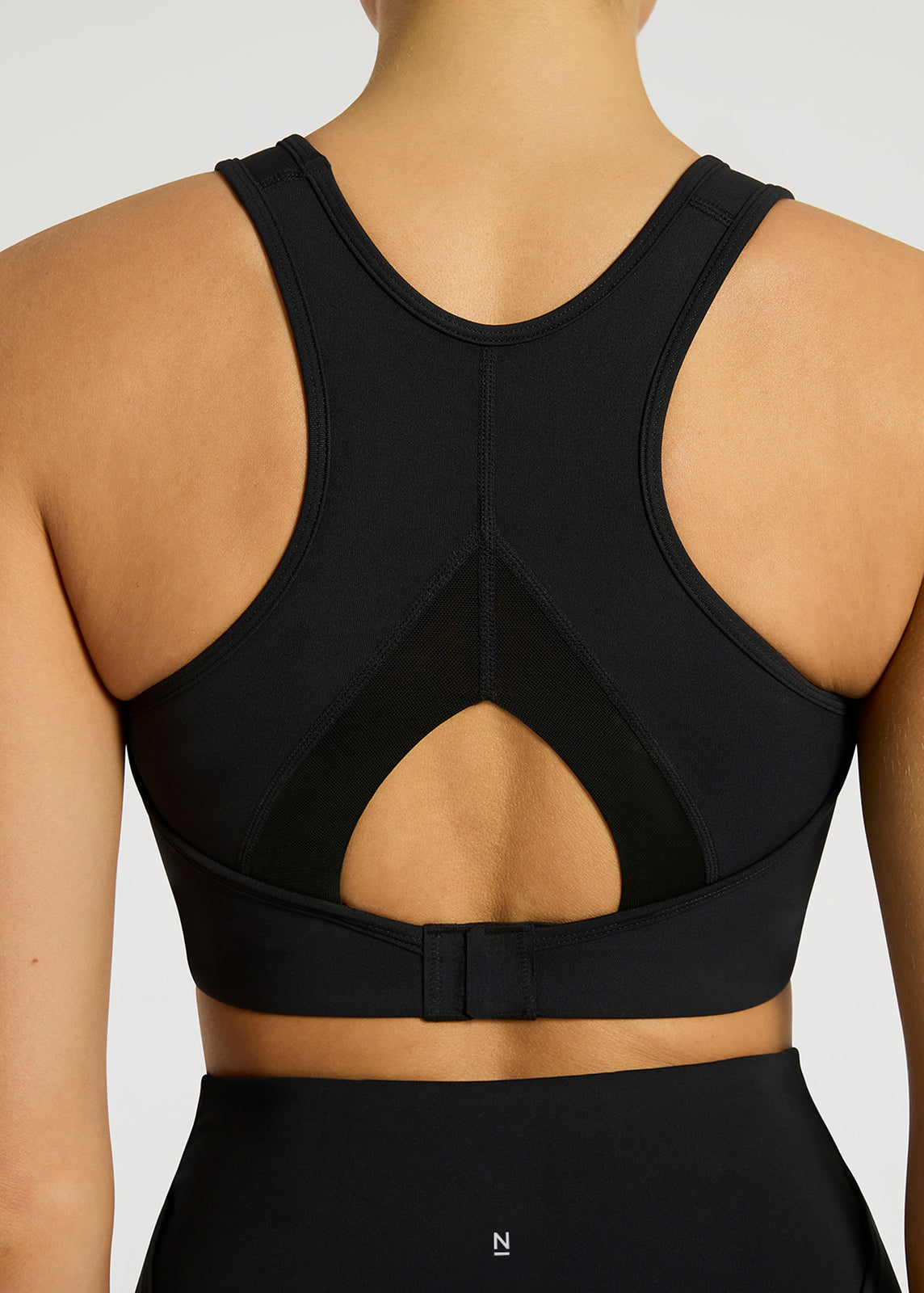 Close-up of model wearing black racerback sports bra
