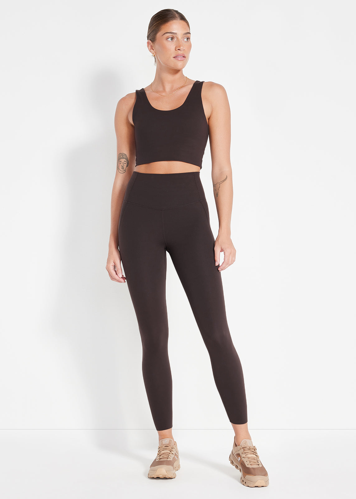 Woman wearing chocolate brown seamless crop top and matching high-rise leggings, made for movement and comfort