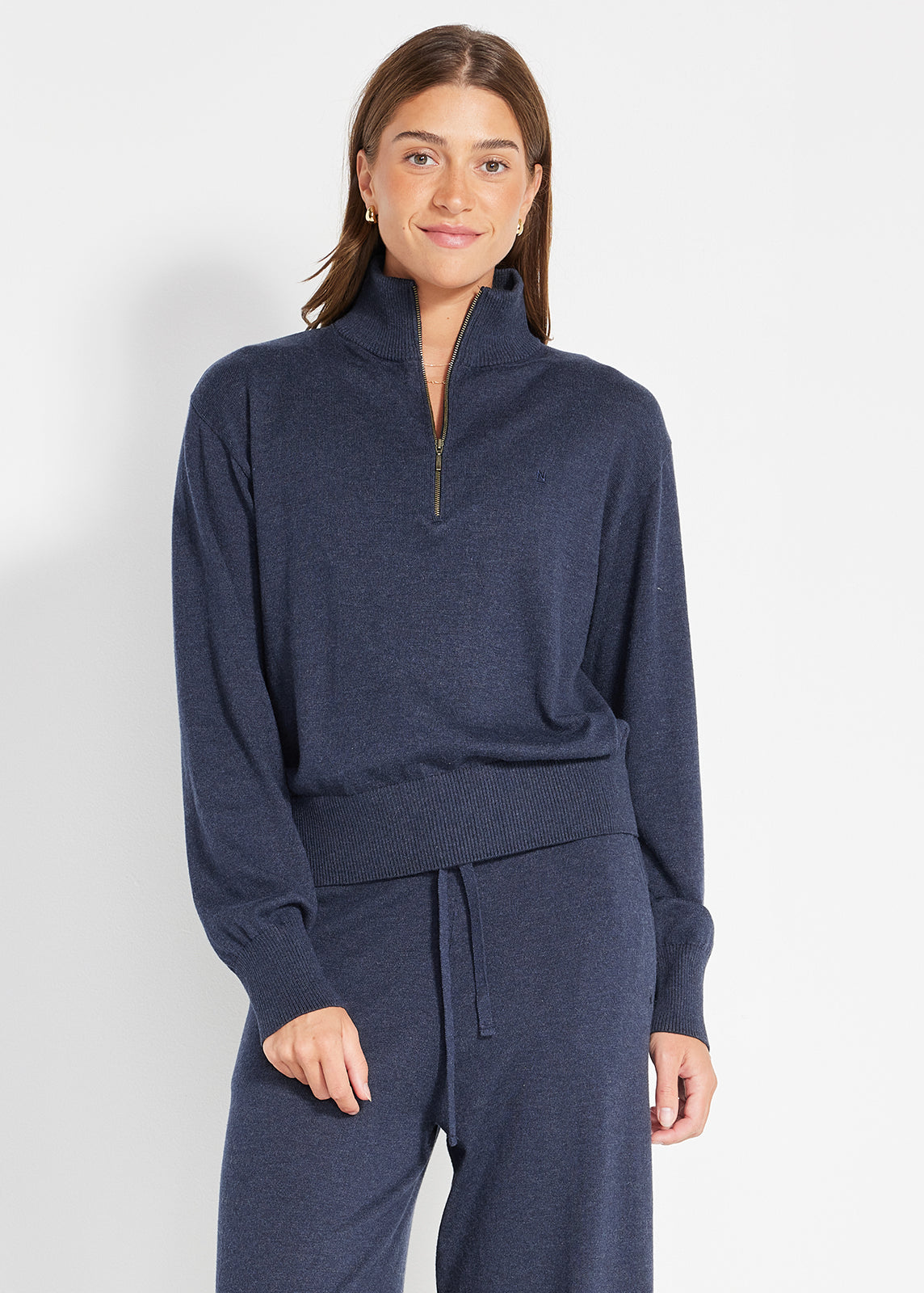 Model wearing navy knit half-zip jumper with ribbed hem and cuffs, paired with matching drawstring pants