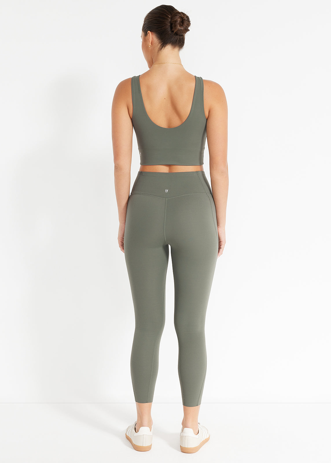 Product image showing model wearing olive green crop top and matching high-rise leggings