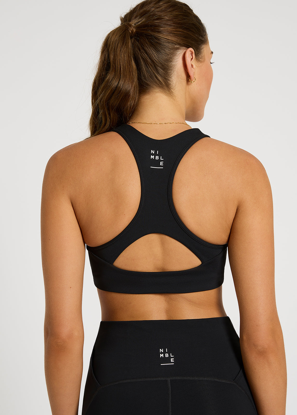 Close up of model wearing Tempo racer black sports bra