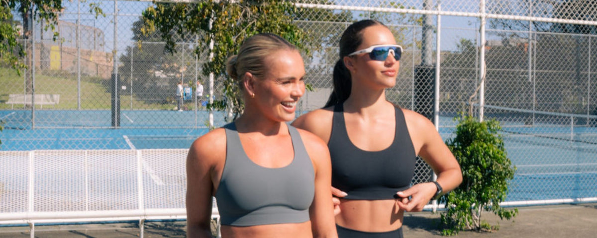 Two runners standing at a tennis court wearing Nimble In Pace activewear.
